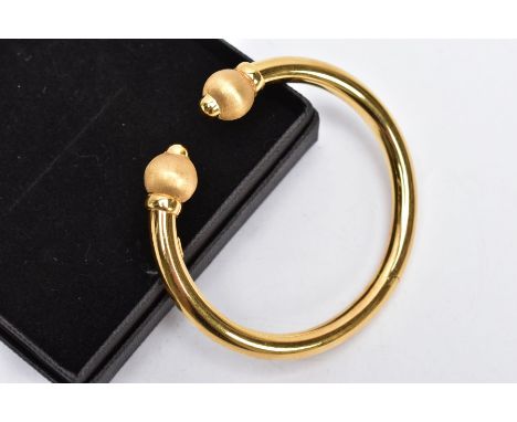 A MODERN 18CT GOLD HINGED TORQUE BANGLE. A plain polished bangle section which has a hinge to the middle, terminated at each 