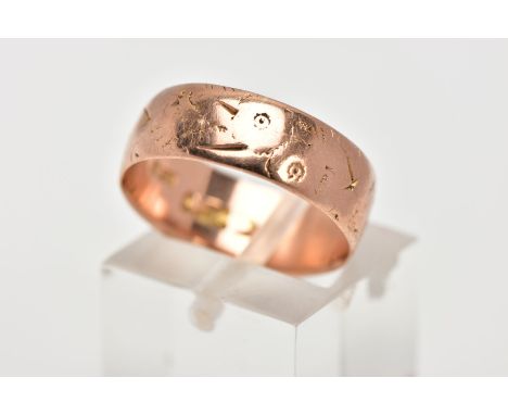 AN EARLY TWENTEITH CENTURY 9CT ROSE GOLD WEDDING RING. Measuring 6.7mm in width, engraved pattern (very worn), ring size O, h