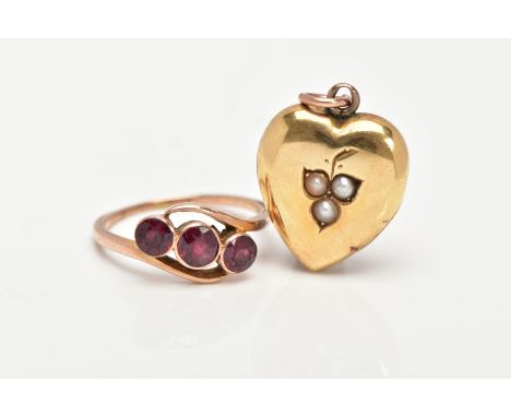 A YELLOW METAL THREE STONE RING AND A YELLOW METAL LOCKET, the ring designed with three graduated, circular cut red stones as