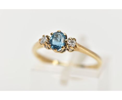 A 9CT GOLD THREE STONE GEM RING, the central oval blue topaz flanked by brilliant cut diamonds, all within claw settings, est