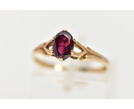 A 9CT GOLD GARNET RING, the oval garnet within a six-claw setting, to the bifurcated shoulders, 9ct hallmark for London, ring