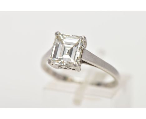 AN EMERALD CUT SINGLE STONE DIAMOND RING, the emerald cut diamond within a four claw setting to the plain band, estimated dia