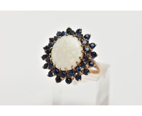 A LARGE 9CT GOLD OPAL AND SAPPHIRE RING centring on an oval cabochon white opal, measuring 14.2mm x 12.0mm, enclosed within a