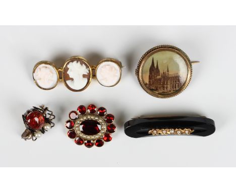 A gold, garnet and seed pearl brooch, circa 1910, mounted with the principal oval cut garnet within a surround of seed pearls