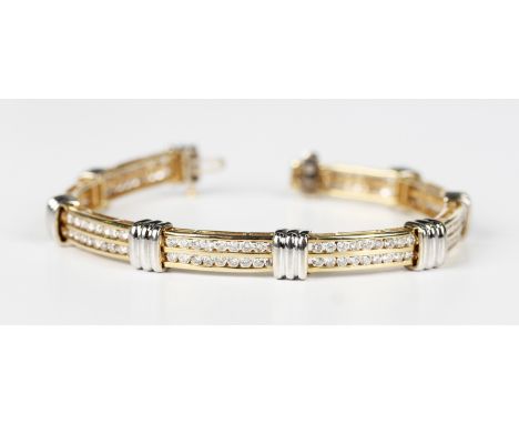 A two colour gold and diamond bracelet in a curved bar and ridged oval design, mounted with two rows of nine circular cut dia