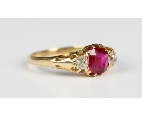 A gold, ruby and diamond three stone ring, claw set with the cushion cut ruby between two cushion cut diamonds, detailed '18c