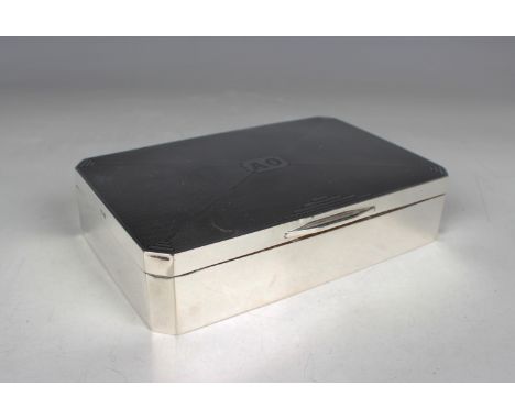 A George V silver canted corner rectangular cigarette box, the engine turned hinged lid with geometric decoration and initial