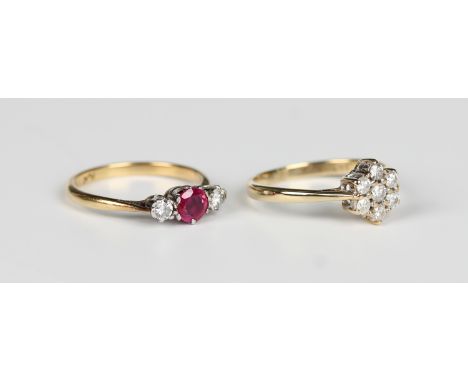 A gold, platinum, ruby and diamond three stone ring, claw set with the circular cut ruby between two circular cut diamonds, d