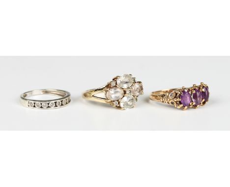 A 9ct gold ring, claw set with a row of three oval cut amethysts, ring size approx O1/2, a 9ct white gold and diamond nine st