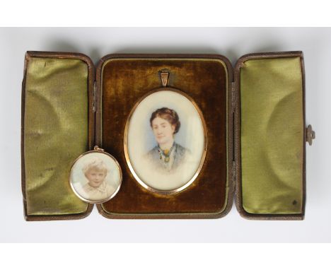 A gold mounted circular pendant locket, the glazed back and front mounted with portraits of children, detailed '9ct', weight 