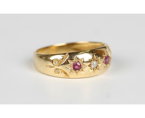 An Edwardian 18ct gold, ruby and diamond three stone ring, star gypsy set with two cushion cut rubies and a cushion cut diamo