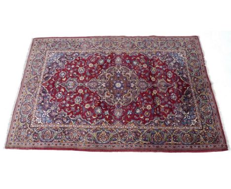 A Kashan rug with claret ground, floral scrolling medallion and pendant anchors to the centre, floral field, dark blue, light