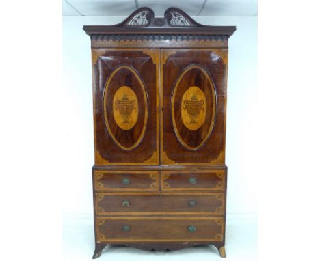 A George III style mahogany, satinwood banded and inlaid linen press, 19th century with later restoration, the broken swan ne