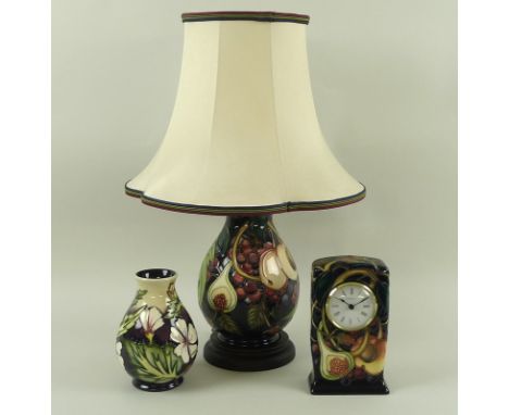 A group of Moorcroft ceramics, comprising a lamp with stand and shade, 45cm high, a clock, 9 by 5 by 16cm high, both in The Q