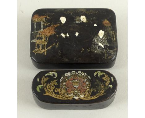 A 19th century papier mache oval snuff box, the black ground painted with scrolling acanthus leaves framing a central medalli