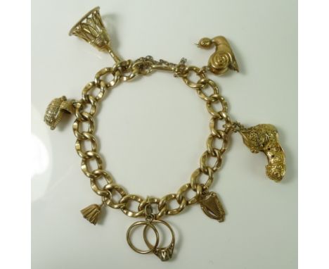 A 9ct gold charm bracelet with seven 9ct gold charms, including a snail, harp, shoe and a baby in a Moses basket, with safety