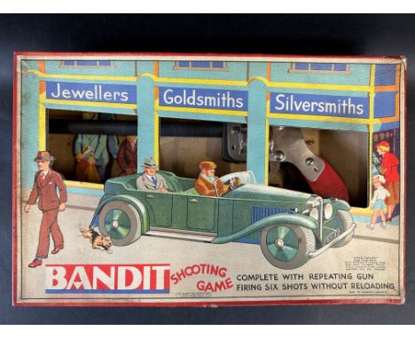 A boxed Chad Valley Bandit Shooting Game, depicting a pre-war open top motor car to the front of the box.