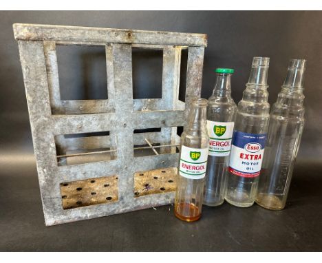 Three quart oil bottles, BP Energol, Essolube and Esso Extra plus a pint BP Energol and a galvanised crate.