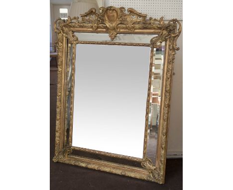 WALL MIRROR, 19th century giltwood and gesso moulded cushion shaped with bevelled mirror and marginal plates and 'C' scroll c