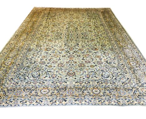 FINE KASHAN CARPET, 404cm x 295cm, palmette and vine design on a jade field within complimentary bands and borders.