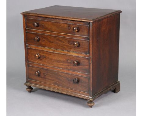 A Georgian mahogany chest commode with moulded edge to the hinged lift-top, above four long graduated mock drawers with turne