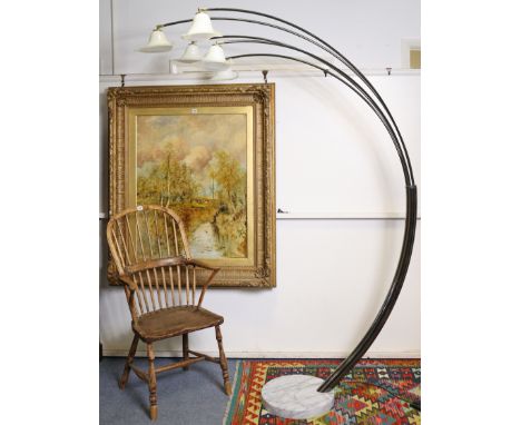 A contemporary silvered-metal floor-standing lamp with five rounded arms, each fitted with a glass shade, &amp; on a white ma