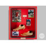 A pair of gold coloured cast football boots.