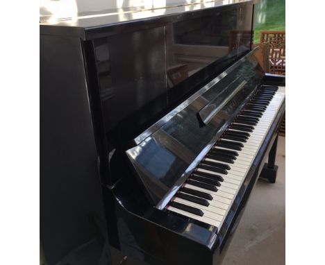 Kawai (c1968)An upright piano in a traditional style bright ebonised case; together with a matching stool. 