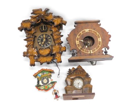 A Black Forest style cuckoo clock, another cuckoo clock, a Vienna wall clock, and a Swiss mantel clock, carved with chalet, f