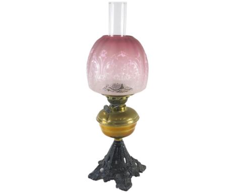 A Victorian brass iron oil lamp, with etched pink tinted Art Nouveau shade, the base 31cm high. 
