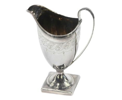 A George IV silver cream jug, the fluted and pierced spout and shaped handle, with engine turned floral decoration, on a squa