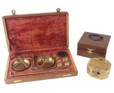 A brass pocket compass, in brass case with hardwood carry box and a pair of scales. (2)