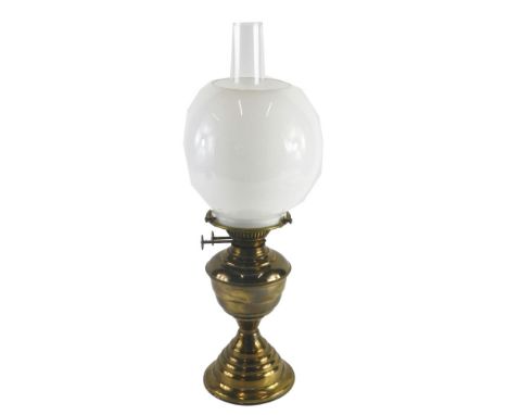 A brass oil lamp, with opaque white globe shade, and an hourglass shaped moulded base, 50cm high. 