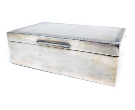 An Elizabeth II silver cigarette box, engine engraved decoration, Birmingham 1954, 12cm wide.