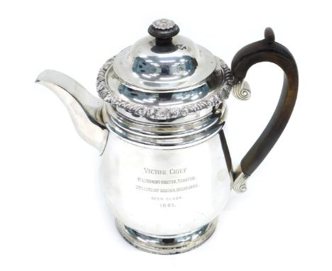 A Victorian silver teapot, with floral engraved rim, crested scroll wooden handle, London 1893, 32oz all in, 23cm high.