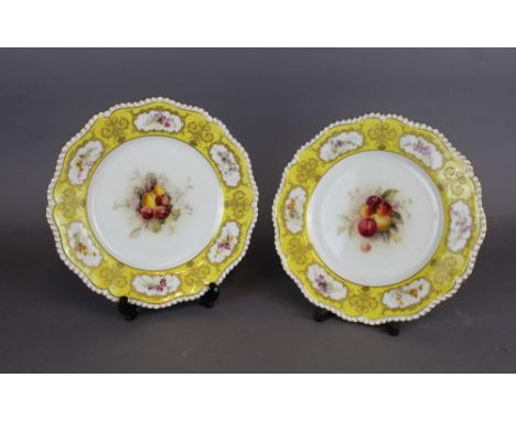 A pair of Royal Worcester porcelain yellow ground plates, decorated to centres with fruit by William Ricketts, 23.5cm diamete