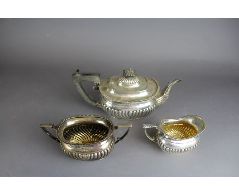 A George V silver three piece tea service by George Unite, with bulbous reeded bodies, comprising tea pot, milk jug and sugar