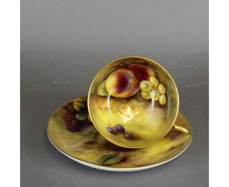 A Royal Worcester porcelain tea cup and saucer, both decorated with fruit, the cup by H Everett, the saucer by A.G. Moseley, 