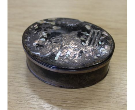 An early/mid 19th Century tortoiseshell oval snuff box, the lid with silver pique and mother of pearl inlay depicting seated 