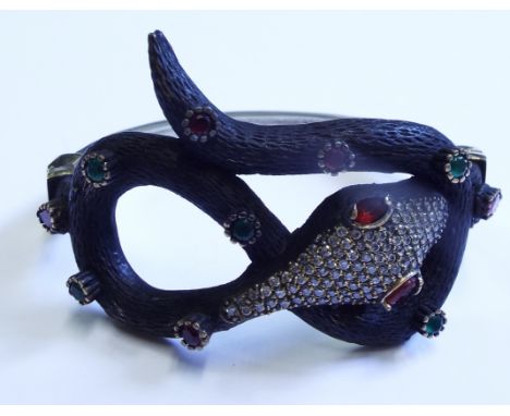 A silver, emerald and ruby bangle, in the form of a snake

We will post this item worldwide at cost. No packing charge. 