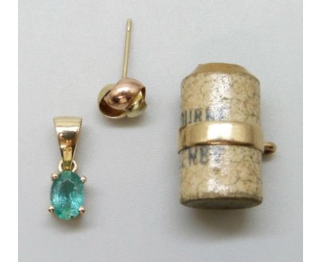 A yellow gold and emerald pendant with a yellow metal stud earring and a yellow metal stoneware flagon charm 