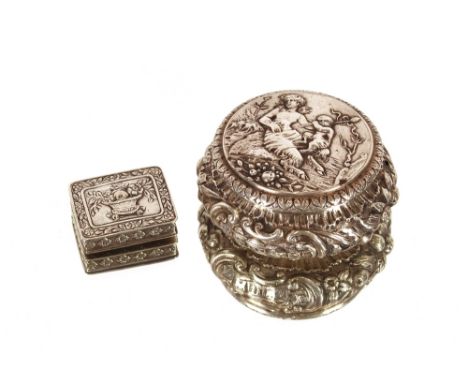 A late 18th/early 19th Century Continental white metal circular box, decorated with buildings, fruit and two hoofed figures; 