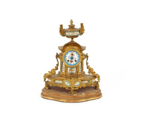 A 19th Century French ormolu mantel clock, with Sevres type panels, decorated with flowers and objects, surmounted by an urn 