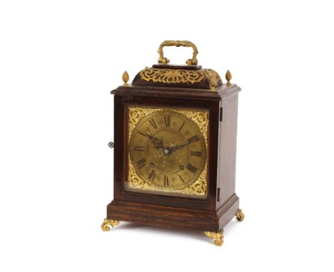 An early 20th Century oak cased and brass mounted bracket clock, having pierced foliate decoration with pineapple finials, th
