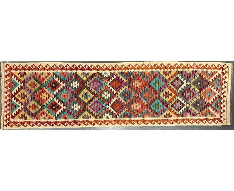 A 20th century Anatolian Turkish Islamic Kilim floor carpet runner rug. The rug having a a central panel with a series of rep