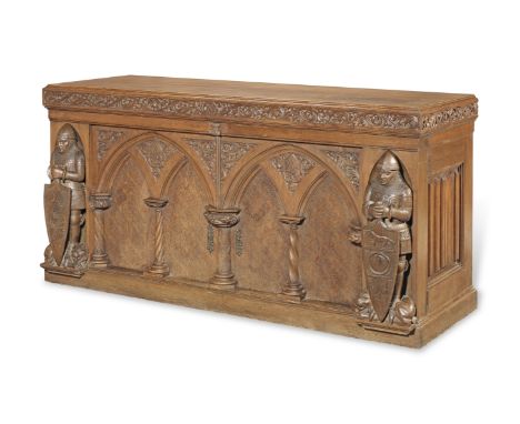 A large Austrian 'gothic revival' carved oak side cabinetWith a pair of doors each carved as a blind pointed twin-arched pane