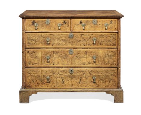 A Queen Anne walnut and featherbanded chestThe quarter veneered top with an ogee moulded edge, above two short and three long