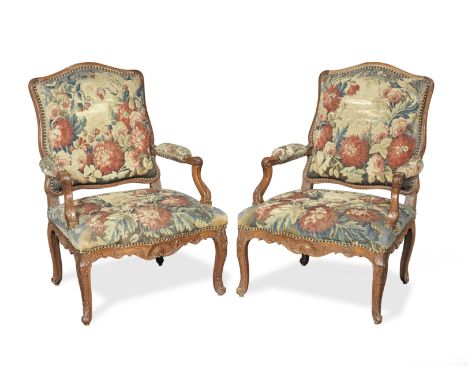 A pair of early Louis XV carved beech fauteuilsCirca 1740, each with associated 18th century floral tapestry upholstery and a