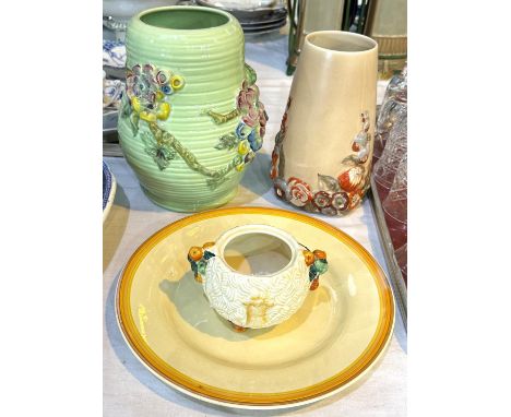 Two Clarice Cliff vases with raised floral decoration, heights 23 and 20cms; a Clarice Cliff plate and preserve pot (no lid).