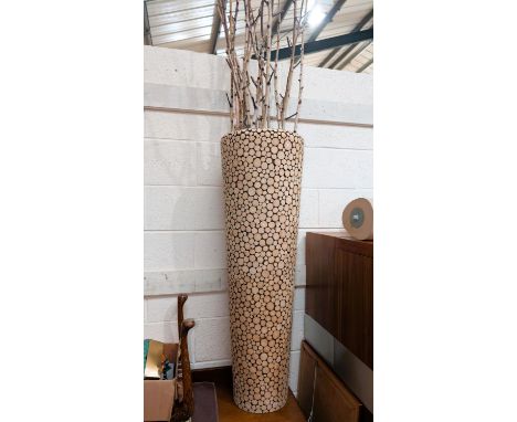 A tall wood effect planter with decorative branches, height 110cm.